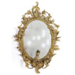 An early 19th century girandole, the oval mirror plate in gilt gesso rococo frame with floral