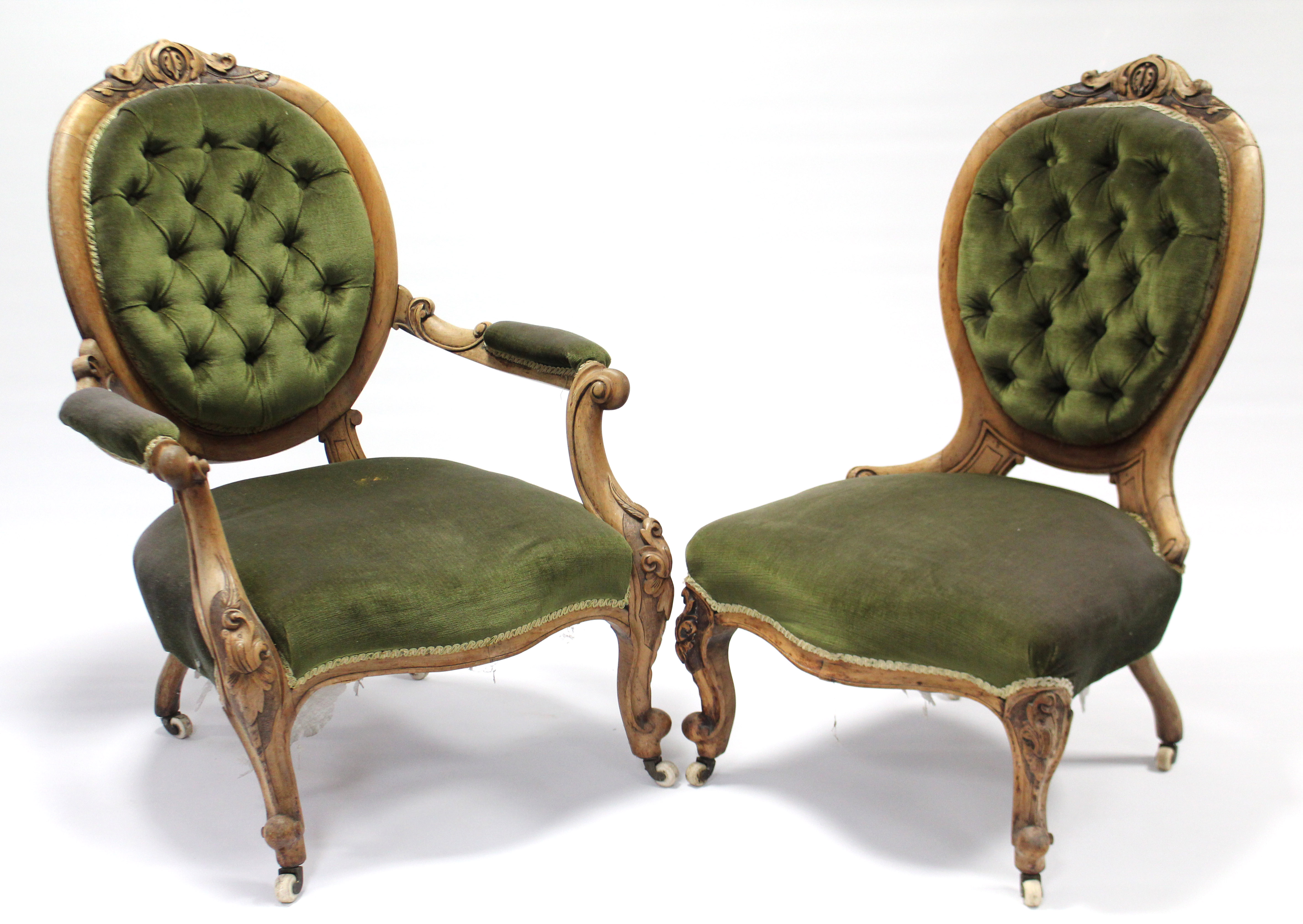 A mid-Victorian carved walnut frame armchair with rounded buttoned-back, open scroll arms, &