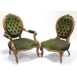 A mid-Victorian carved walnut frame armchair with rounded buttoned-back, open scroll arms, &