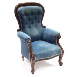 A late Victorian mahogany spoon-back armchair with padded seat, buttoned back & scroll arms