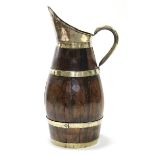 A coopered oak, brass & copper-bound large flagon with copper handle & upright spout; 29” high.