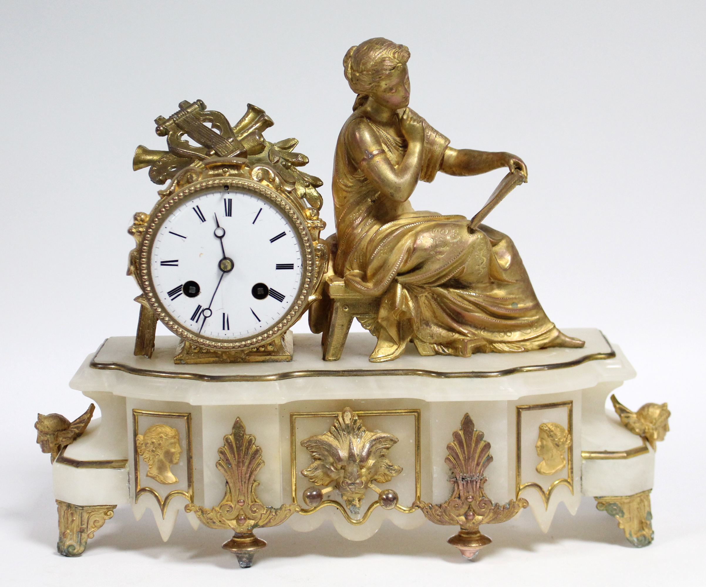 A mid-19th century French mantel clock in gilt-metal figural case, the 3¼” white enamel dial with