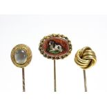 An oval-headed aventurine glass stick pin inset micro-mosaic recumbent spaniel; a 15ct. gold stick
