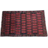 A Baluchi rug of deep-blue & crimson ground with central geometric panel within multiple borders;