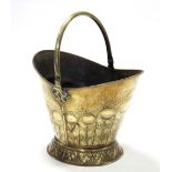 A 19th century brass coal scuttle with embossed foliate decoration, the swing handle with pierced