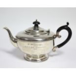 A George V silver teapot of squat round form with narrow beaded rims, ebonised scroll handle, &on