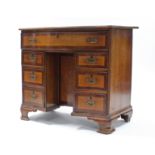 A George III oak & mahogany crossbanded serpentine-front kneehole dressing table, fitted long frieze