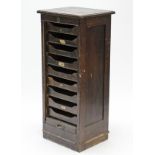 An Edwardian oak small upright office cabinet, fitted nine sliding trays enclosed by tambour