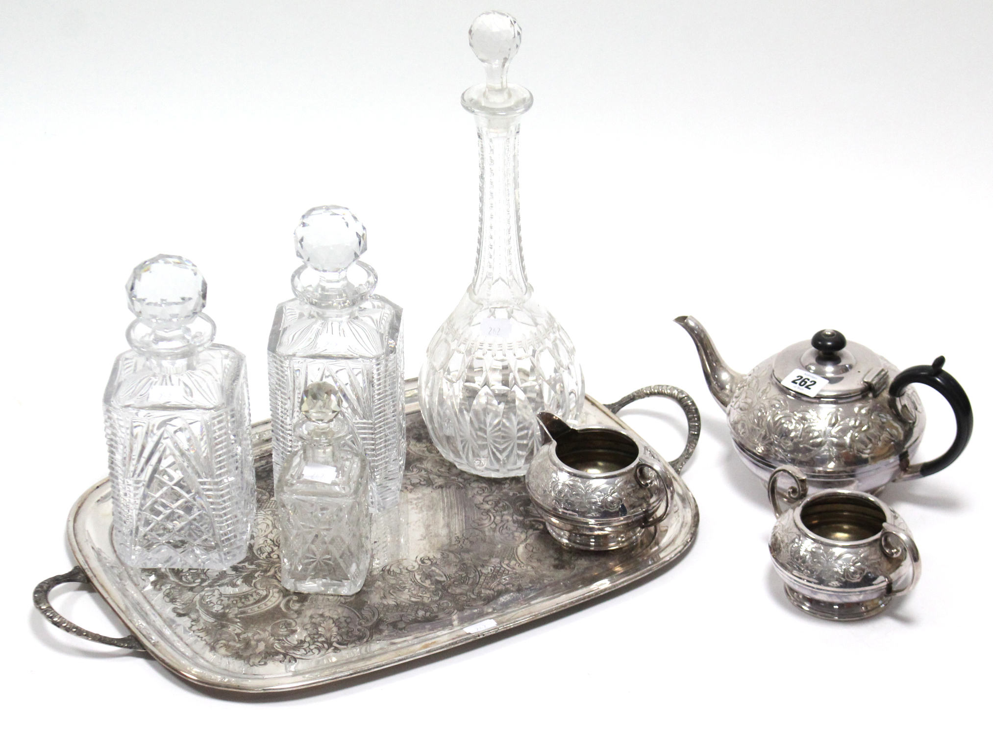 A silver plated embossed three-piece tea service; a similar rectangular two-handled tea tray;