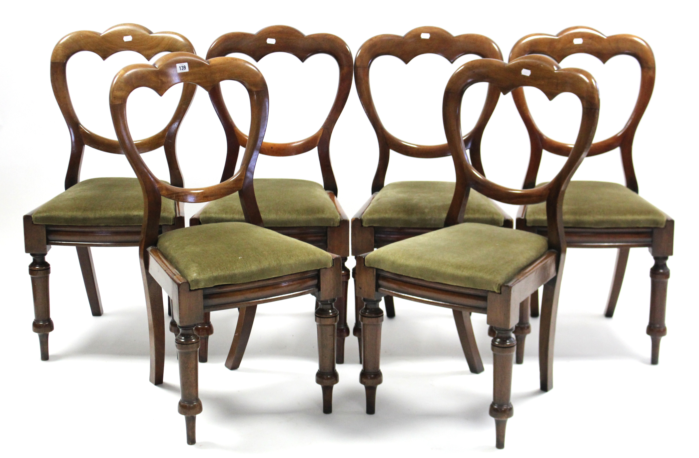 A set of six Victorian mahogany balloon-back dining chairs with padded drop-in seats, & on turned