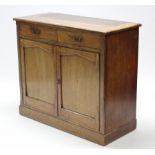 A late 19th century mahogany cabinet, fitted two frieze drawers above cupboard enclosed by pair of