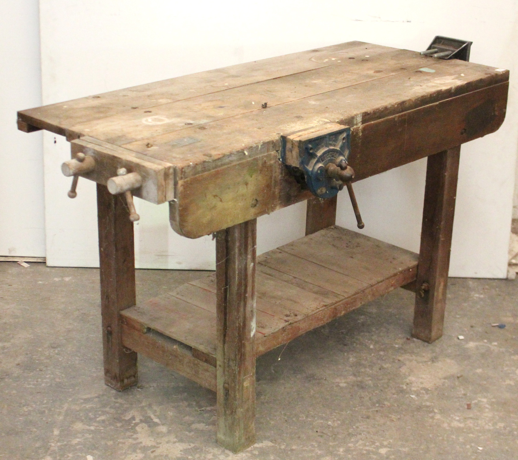 A wooden work bench fitted three clamps, & on square legs, 54” long.