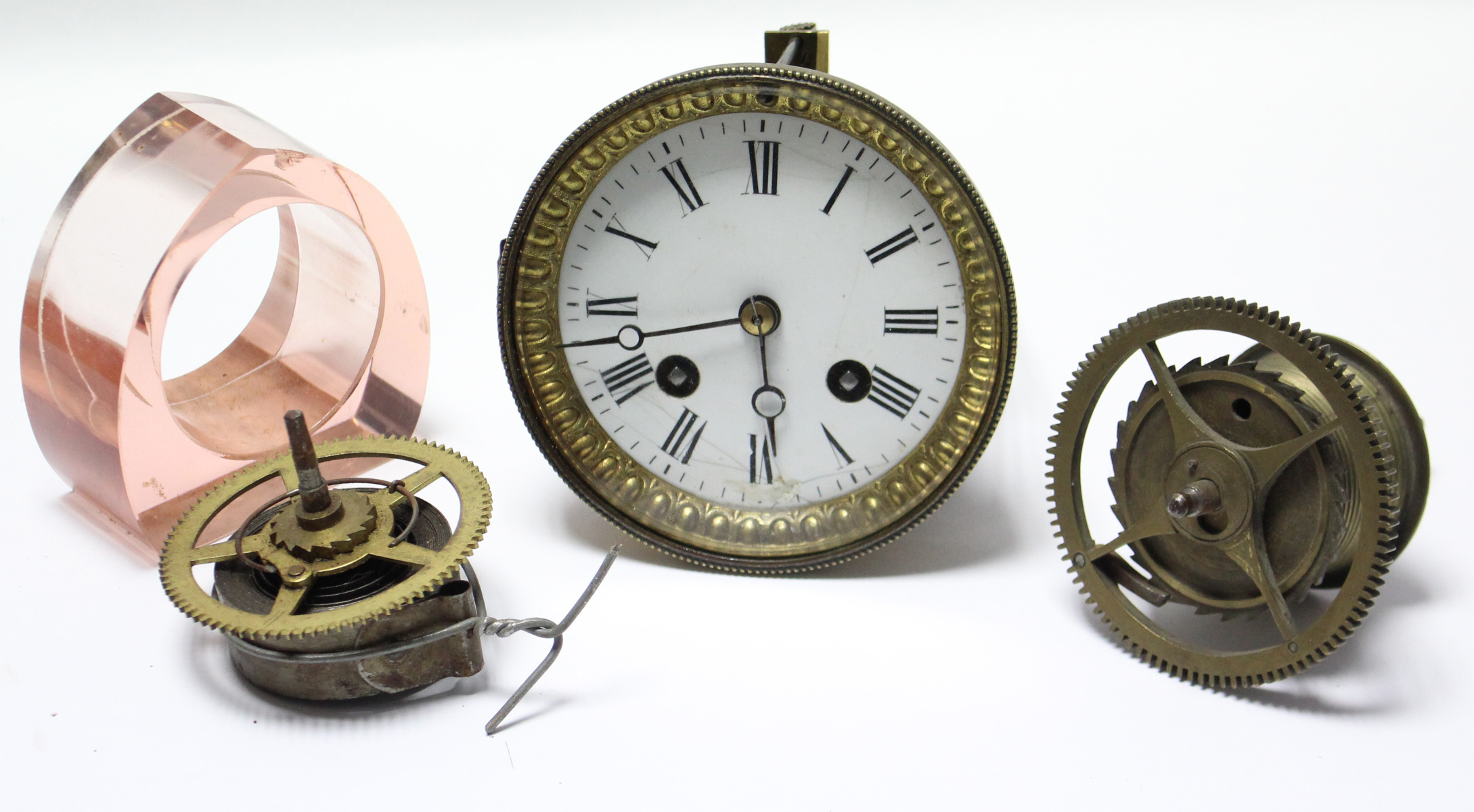 An early 20th century mantel clock mechanism with white enamel dial, 4¼” diameter; & various clock