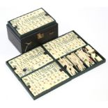 A mid-20th century bone mah-jong set with black morocco leather case.