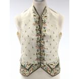 A GEORGIAN CREAM SILK EMBROIDERED WAISTCOAT, with all-over multi-coloured floral decoration, bears