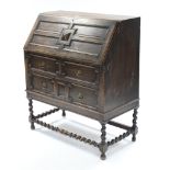 A 1930’s oak bureau with fitted interior enclosed by fall-front above two short & one long drawer, &
