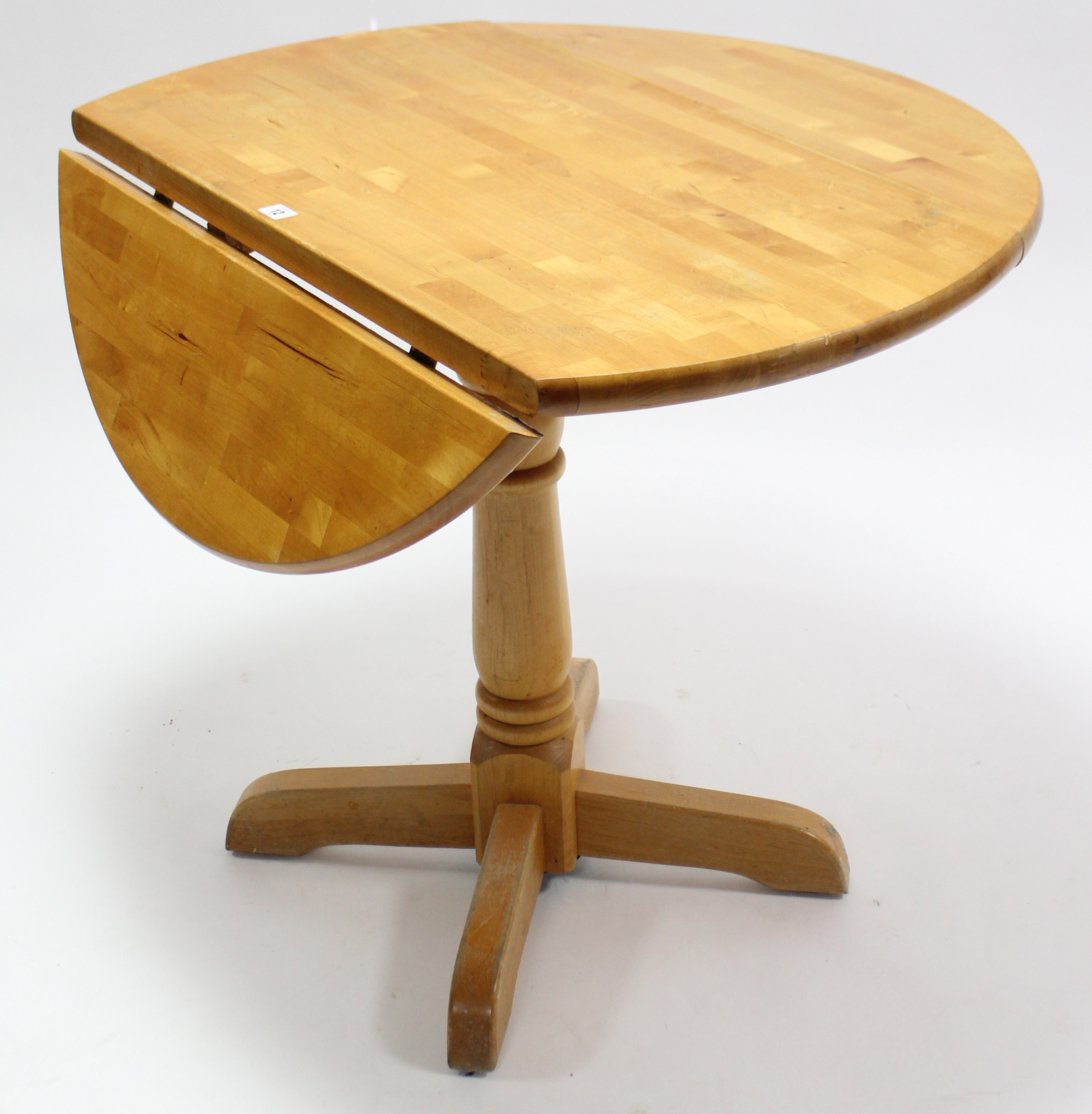 A maple-finish circular drop-leaf kitchen table on turned centre column & four splay legs, 36”