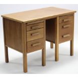 A light oak small desk fitted with an arrangement of five drawers, & on square legs, 40¾” wide.