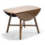 An Ercol elm circular drop-leaf dining table (re-stained), on four square splay legs with diagonal