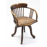 An early 20th century oak lath-back swivel office chair with hard seat, & on four splay legs.