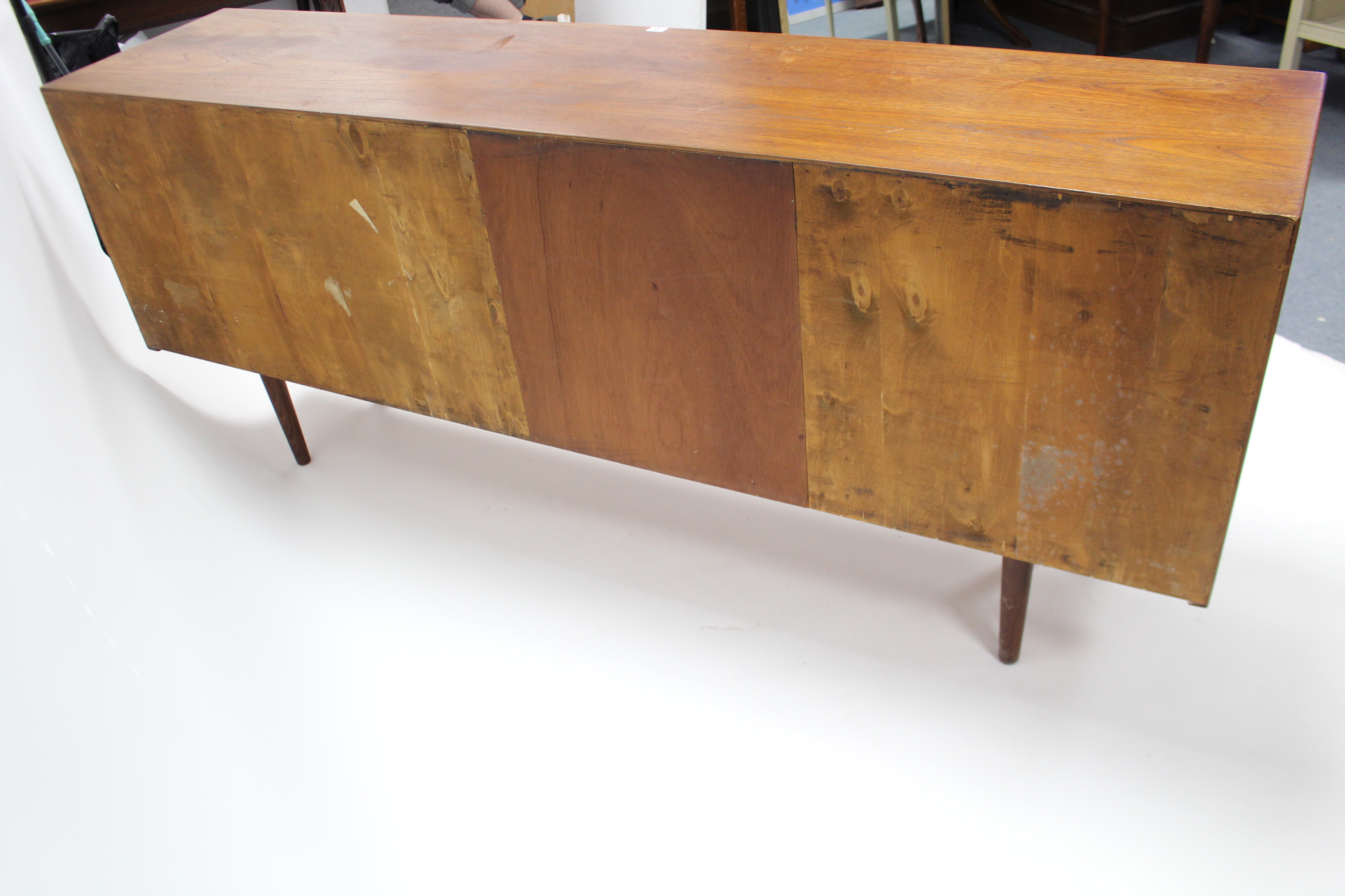 A 1960’s teak sideboard with fitted interior enclosed by two pairs of sliding panel doors, & on - Image 7 of 7
