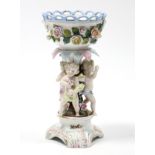 A Sitzendorf porcelain centrepiece with round floral-encrusted bowl supported by three cherubs, on