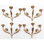 A set of four gilt-metal triple-branch wall sconces, 17” wide x 12” high.