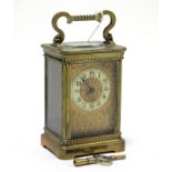 A late 19th/early 20th-century brass-cased carriage clock with white enamel & gilt metal two-part
