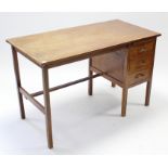 An oak typist’s desk, fitted with a brushing slide above three long graduated drawers to the right-