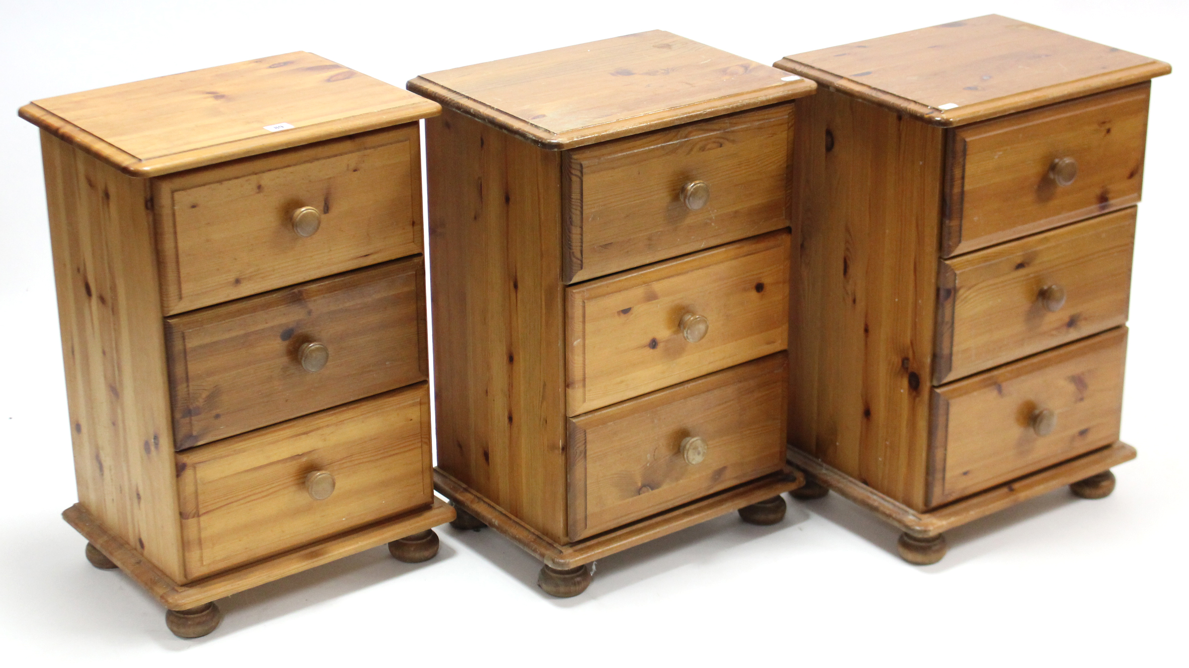 A set of three pine three-drawer bedside chests, 17” wide.