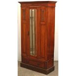 A late Victorian carved mahogany small wardrobe enclosed by rectangular bevelled mirror door to