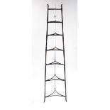 A wrought-iron seven-tier saucepan stand of triangular form, 56¼” high.