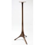 A mahogany torchere with circular top, & on round tapered centre column & three splay legs, 54½”