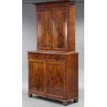 A late Regency figured mahogany tall cabinet, fitted two frieze drawers with turned knob handles