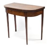 A Regency figured mahogany card table, the rectangular fold-over top with wide crossbanding &