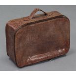 A snakeskin small suitcase with tan leather lining.