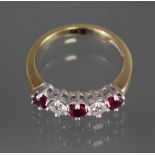An 18ct. gold ring set three rubies with two diamonds in between; size: K/L; weight: 4.2gm.