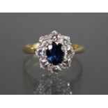 An 18ct. gold ring set oval sapphire within a border of eight diamonds; size: I/J; weight: 3.2gm.