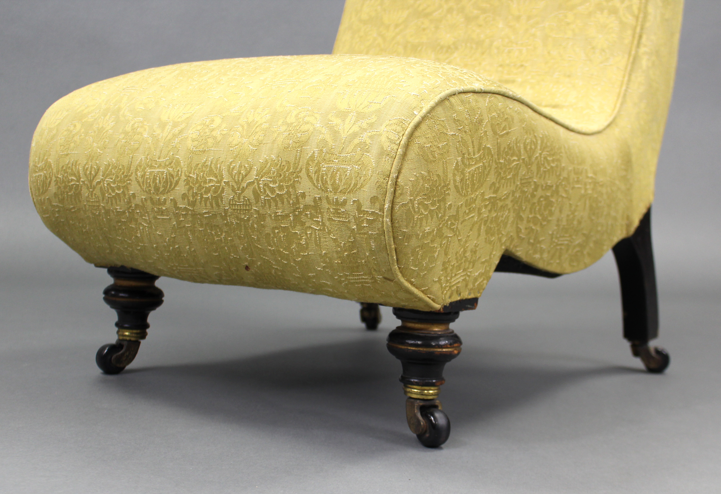 A Victorian nursing chair of scroll shape, upholstered yellow silk with repeating floral motif, on - Image 2 of 5