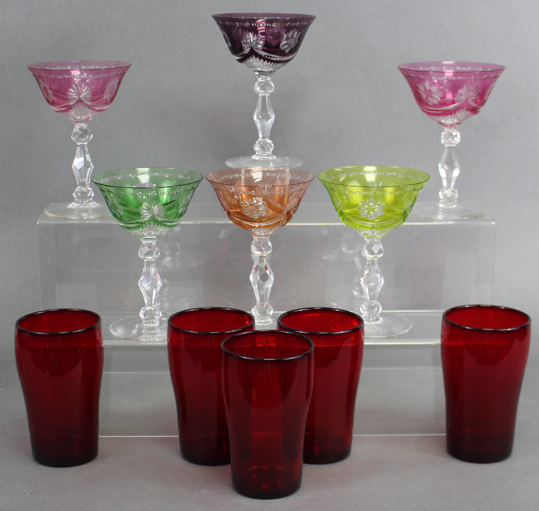 A Harlequin set of six wine glasses, the wide bowls overlaid in different colours & with cut