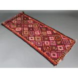 A Kelim runner of pink ground, with all-over geometric lozenge design; 11’ x 3’ 4” (worn).