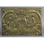 An early 20th century relief-decorated gilt-brass plaque bearing a coat-of-arms with gryphons,