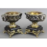 A pair of 19th century bronze & brass two-handled urns of Warwick Vase type, each on black marble