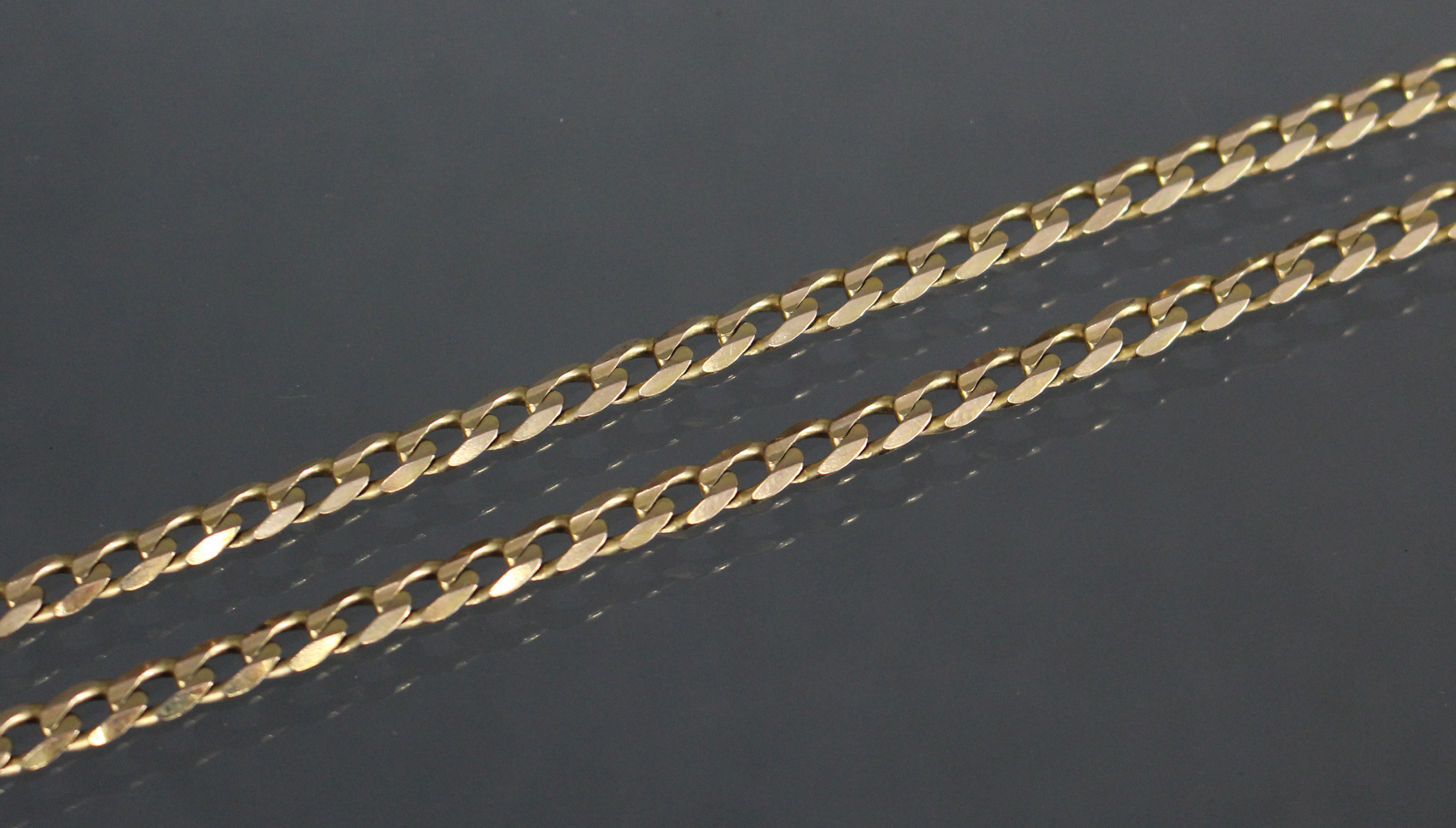 A 9ct. gold necklace of flattened curb links. (21.5gm).