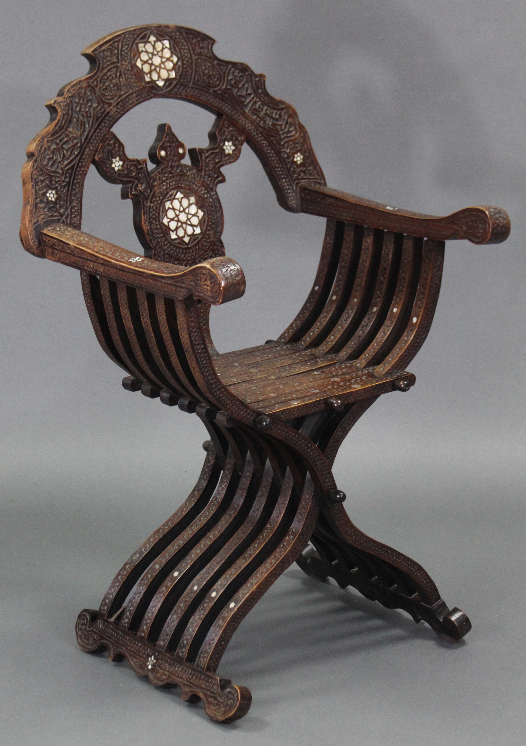 A late 19th/early 20th century carved walnut & mother-of-pearl inlaid Savonarola chair, with pierced