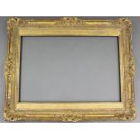 A large 19th century carved giltwood & gesso picture frame with shell & scroll decoration, 45” x 56”