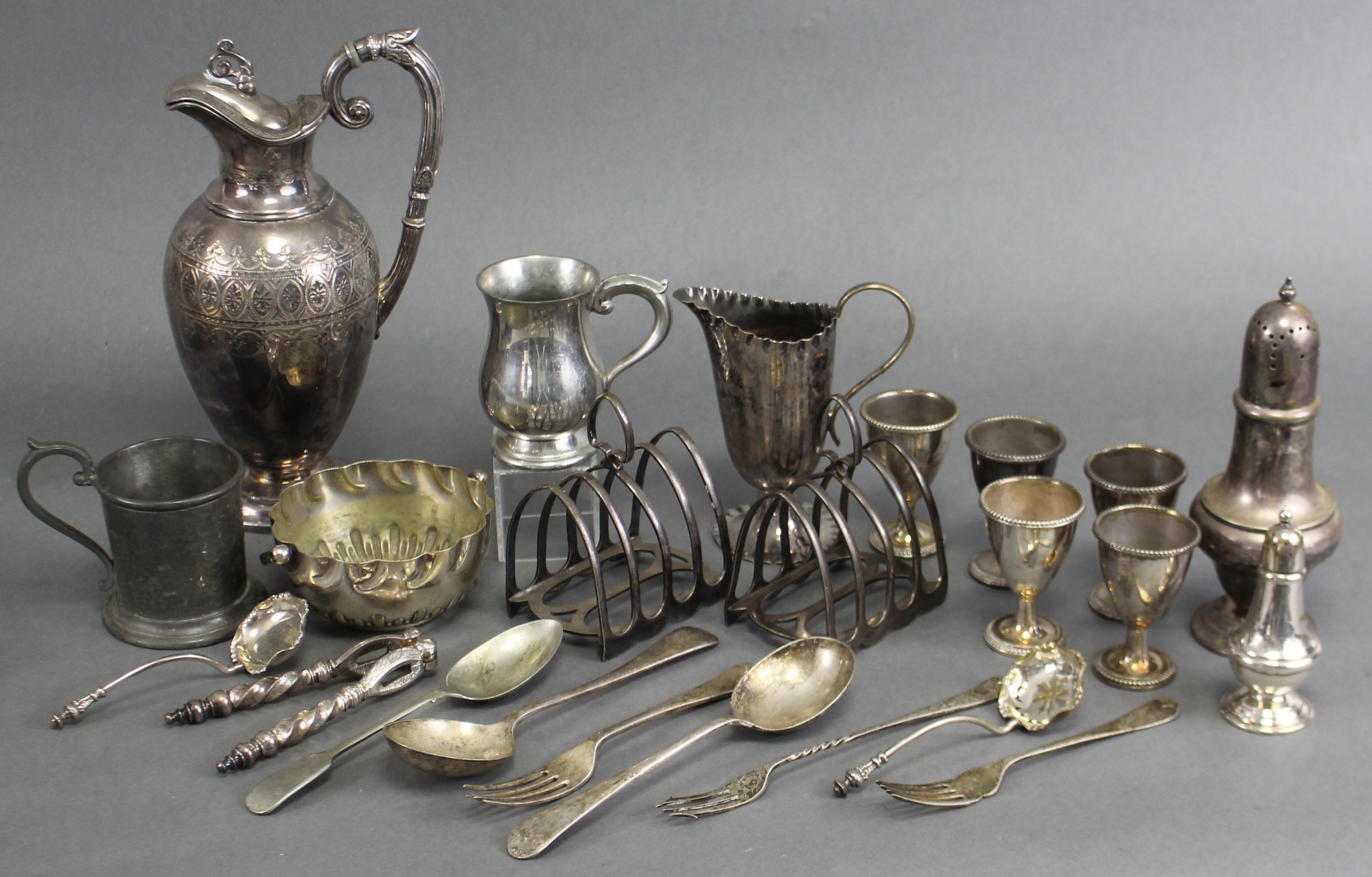 A Victorian engraved wine jug, 9¾”; a pair of four-division toast racks; five egg cups; a baluster