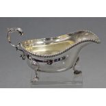 A George V silver large oval sauce boat with gadrooned rim, open acanthus scroll handle, & on