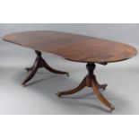 A regency style mahogany twin pedestal dining table with D-shaped end sections, each on turned