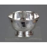 A George V silver small circular bowl with planished surface, beaded rim, & on raised circular foot,